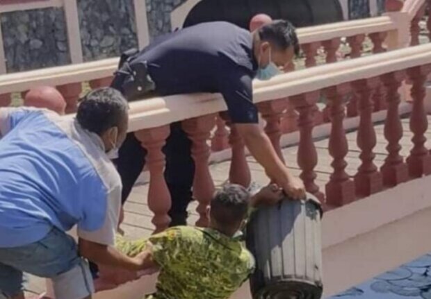 Passersby, a soldier, and a police officer rescued a small animal from the water using a bucket